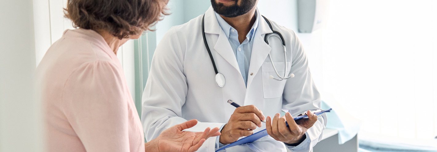 Patient talking with doctor with clipboard